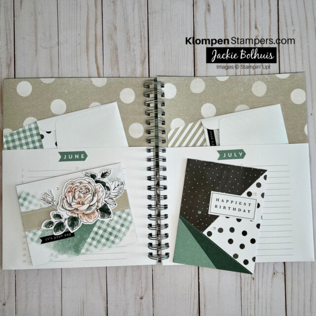 this crafting kit birthday card organizer folder being used, open to pages for the months of June and July with cards placed into organizers pockets
