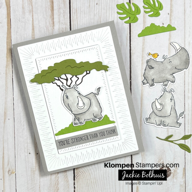 Handmade greeting card designed with Rhino Ready stamp set. Card has a grey card base, white board layer, and a grey rhino in front of a green tree. The card has a sentiment that reads "you're stronger than you think." Image also has two other grey rhinos cut out next to the card to show the different stamps that come in the Rhino Ready stamp set.