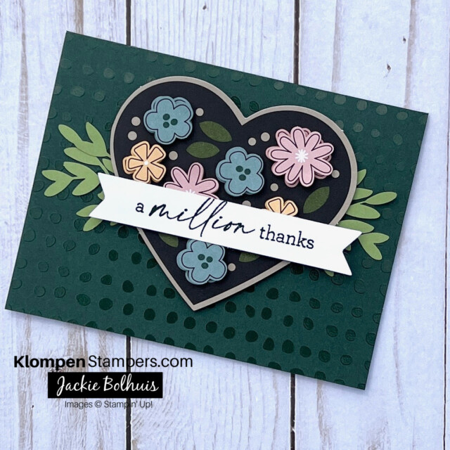 Handmade thank you card created with a thank you card kit. Card base is dark green with a shiny polka-dot texture. There is a large heart with floral embellishments on top. Card sentiment stamped reads a million thanks.