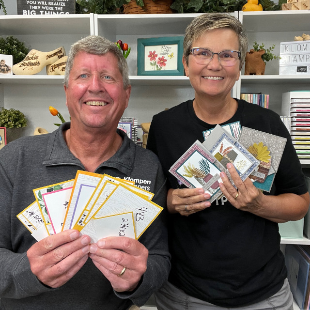 Jackie and Dave of Klompen Stampers holding fun fold card templates and completed cards that were designed from using the card templates.