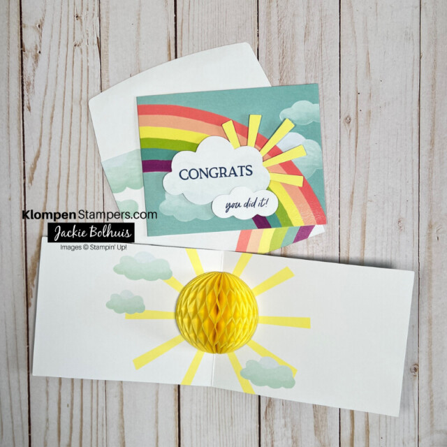 Brightly colored congratulations card. Card front has a rainbow, and the words "congrats, you did it!" are written in clouds that are in front of a sun. Then open the card up and there is a paper honeycomb of a sun in the center of the card.