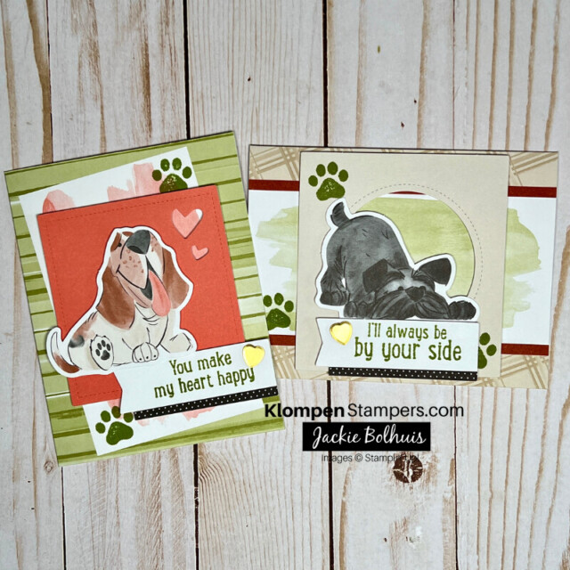 Two cards lying on a table. Both cards are different designs, made with the same brown, green, and pink colors. Each card features a different dog image with small paw prints stamped around them.