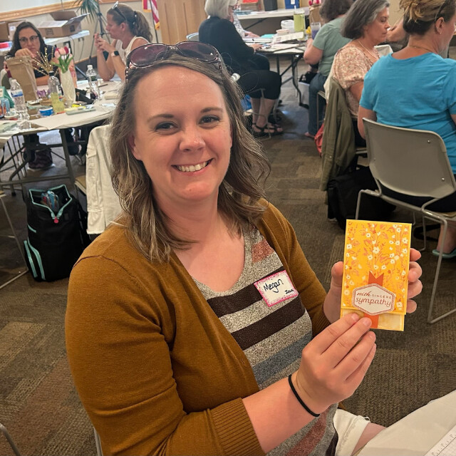 A Klompen Stampers Team member holding her mini slimline card create at a team event held in August 2024.