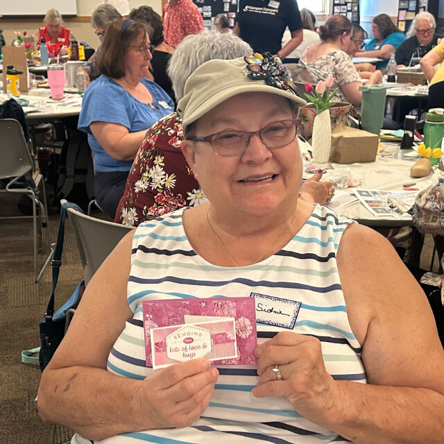 A Klompen Stampers Team member holding her mini slimline card create at a team event held in August 2024.