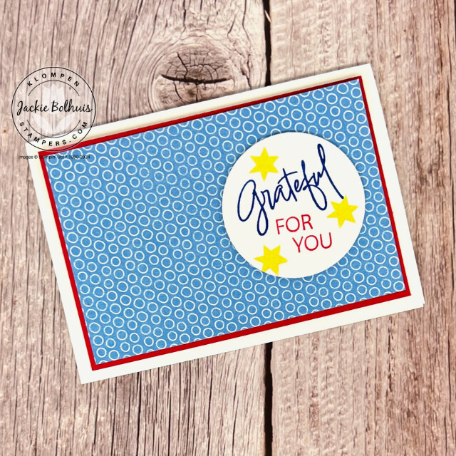 A military appreciation card that is designed with a white card base, red paper layer, blue printed paper, and a small white circle that says "grateful for you" with three stamped stars.