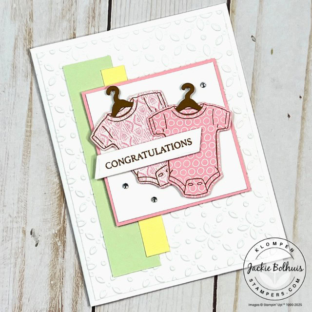 A baby card designed with the Stampin' Up! Cutest Onesie Bundle. Card layout is an easy template from the 48 Card Making Templates resource book. This card has a white card base, a green and a yellow stripe, and two pink onesies on hangers with a congratulations sentiment.