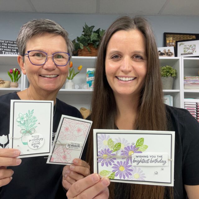 Jackie and Jesi of Klompen Stampers holding handmade cards made in a free class for other paper crafters to learn to make cards.