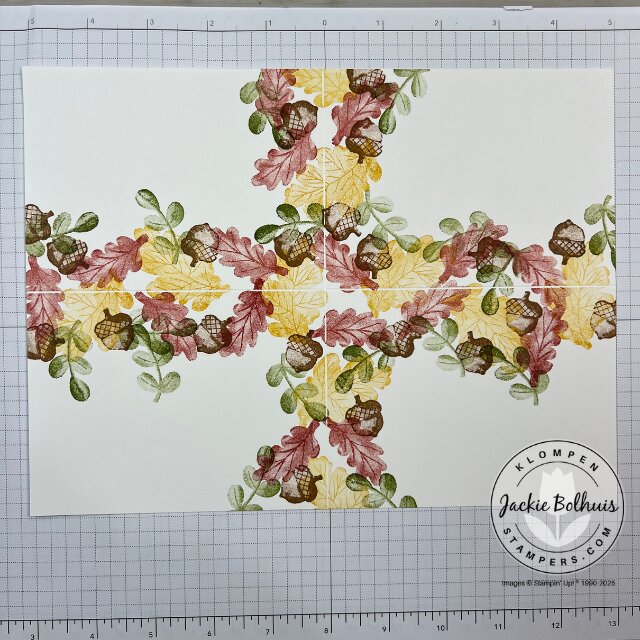 Progress photo showing the nearly completed stamped background sheet filled with fall leaves and foliage images.