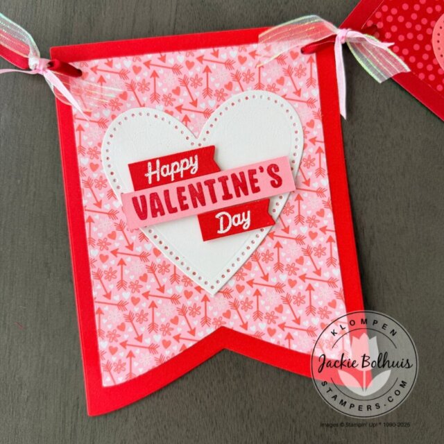 Close-up of a Valentine’s Day banner piece featuring layered cardstock, patterned paper, and die-cut details.